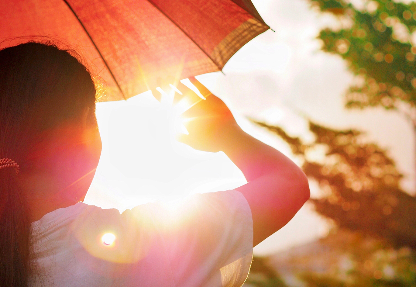 Frau unter Sonnenschirm wird von Sonne geblendet. Visualisiert das Projekt HAP Thüringen.